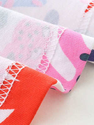 Toddler dress detail showing pink, white, and orange fabric with animal print and stitched seams.