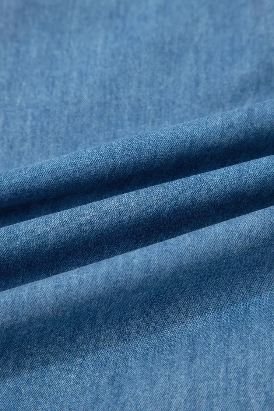 Chambray maternity jeans in a light wash denim with a wide-leg cut and ruffled hem detail.