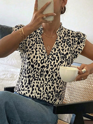 Leopard print blouse with ruffled cap sleeves and a V-neckline.
