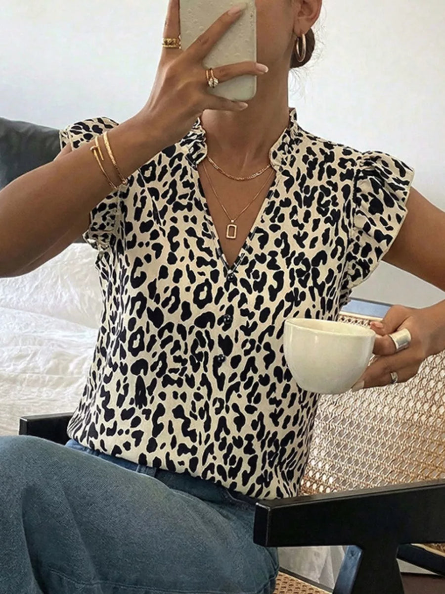 Leopard print blouse with ruffled cap sleeves and a V-neckline.
