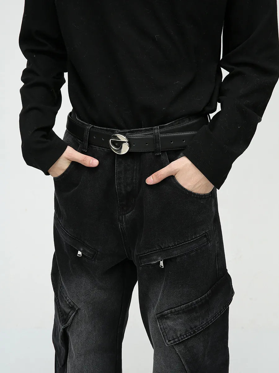 Baggy black denim cargo pants with zipper pockets and a silver buckle belt.
