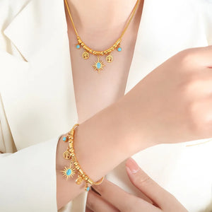 Gold celestial charm pendant necklace with turquoise accents and tree of life charms.