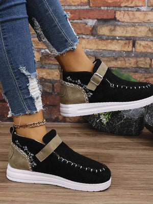 Black textured stitch-detail buckle sneakers with tan accents and white soles.