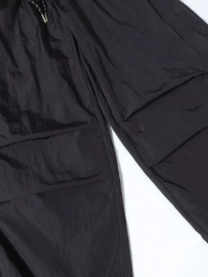 Black wide-leg cargo pants with large flap pockets and drawstring waist.