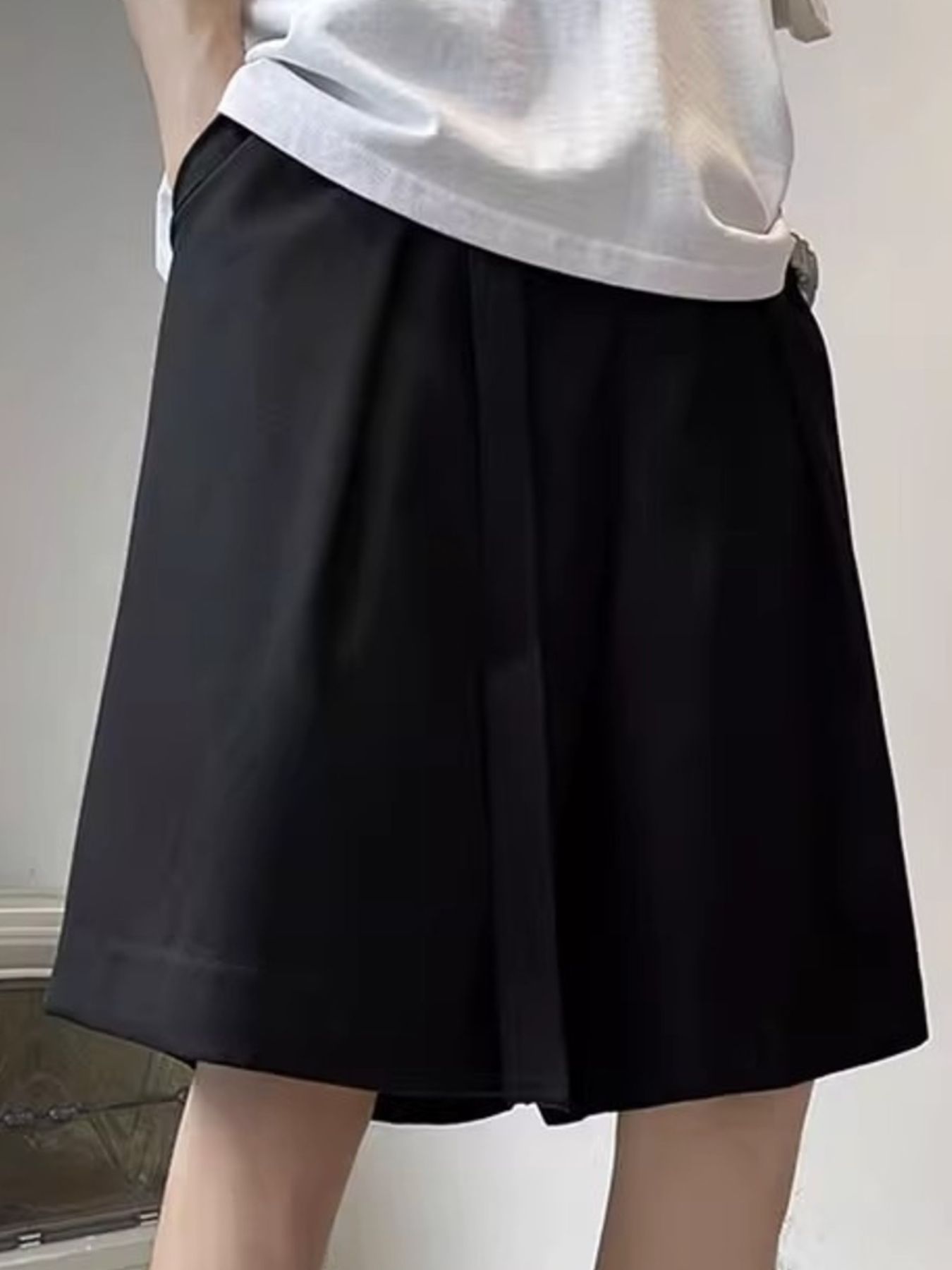 Men's black casual shorts with pockets and a loose fit.