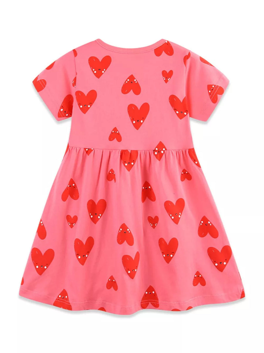 Pink cotton baby dress with playful red heart print, short sleeves, and gathered waist.