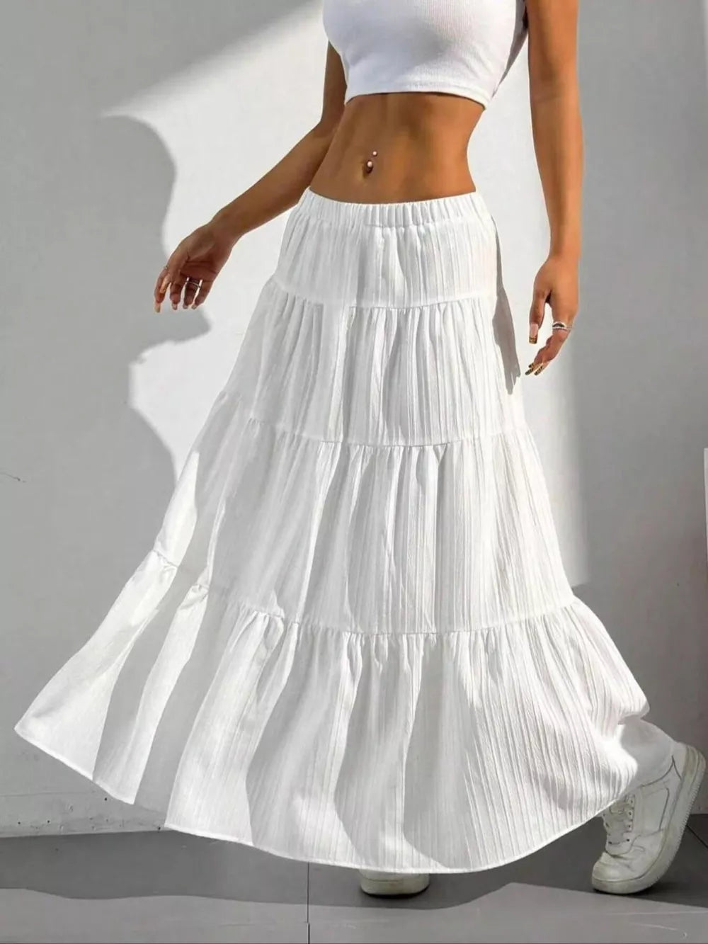 White tiered maxi skirt with elastic waistband and textured fabric.
