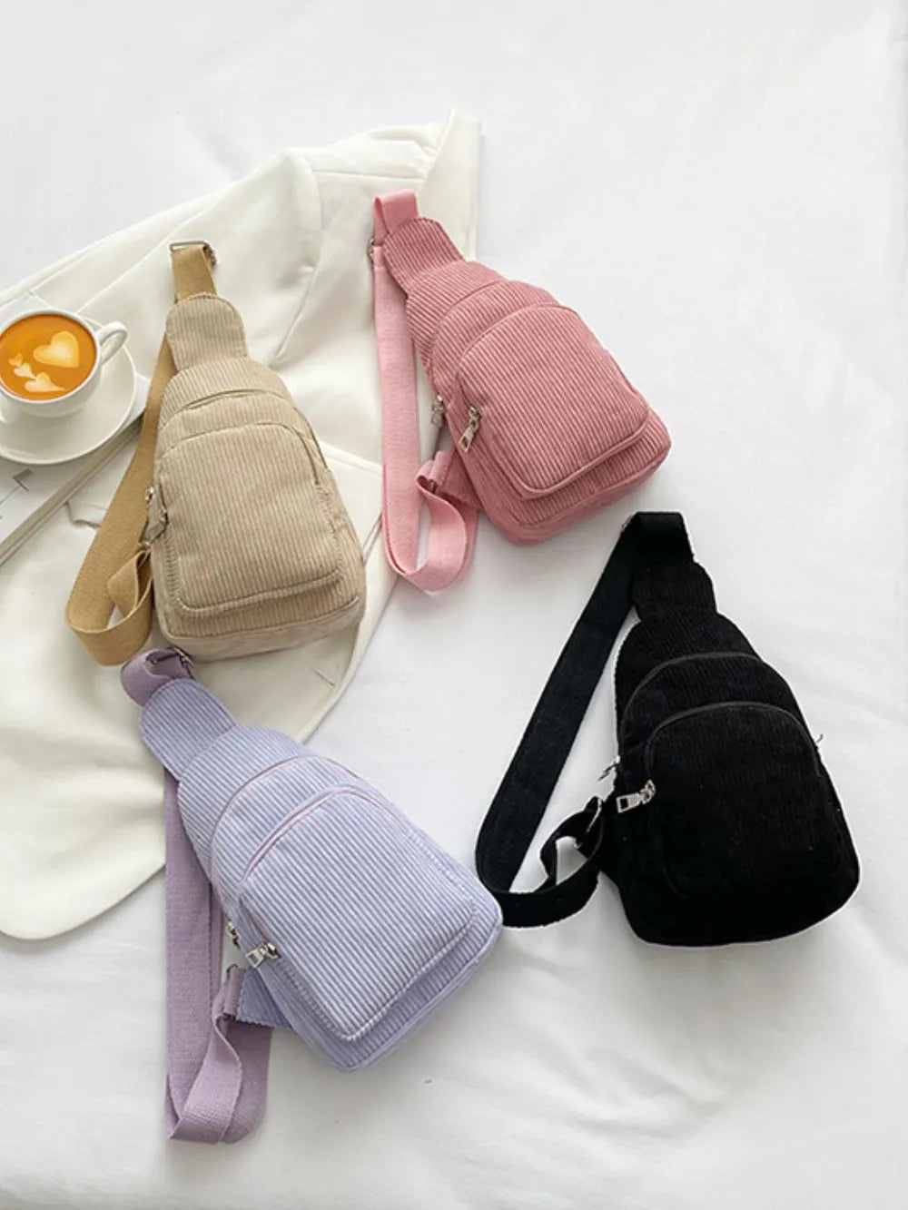 Corduroy sling bag with zip pockets in black, pink, khaki, and lavender.