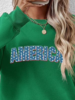 Green crewneck sweatshirt with AMERICA graphic in distressed stars and stripes pattern