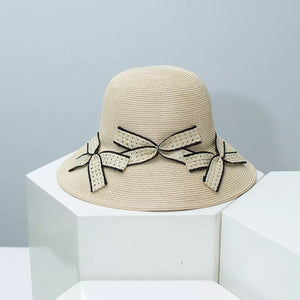 Beige wheat straw sun hat with three decorative bowknots and black trim.