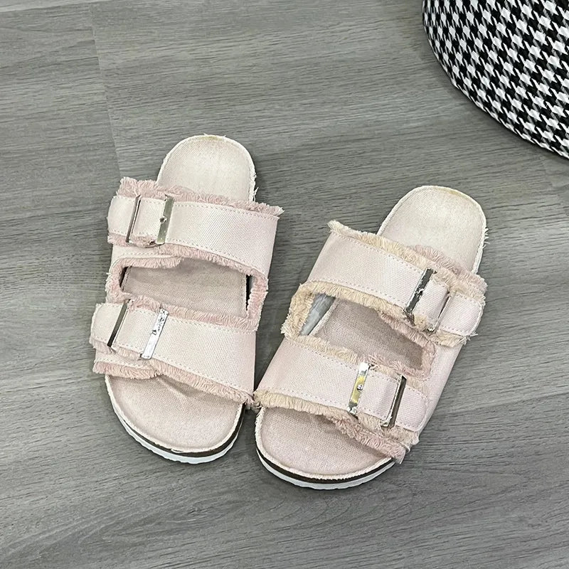 Denim frayed-edge buckle slides in blush pink with adjustable straps.
