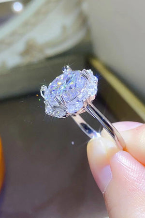 Silver moissanite halo ring with a large oval center stone and smaller accent stones.