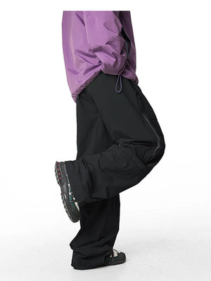 Relaxed black cargo active pants with drawstring waist and zippered pocket detail.