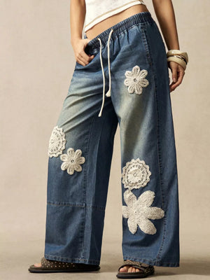 cream wide-leg jeans featuring drawstring waist and floral