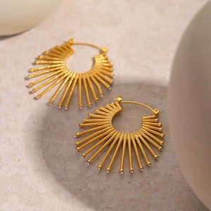 Gold earrings featuring zircon accents and sunburst