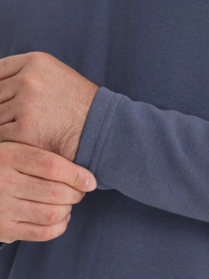Dusty blue polo shirt sleeve detail with ribbed cuff and textured fabric.