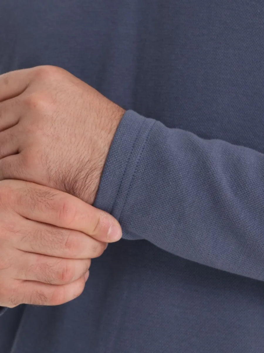 Dusty blue polo shirt sleeve detail with ribbed cuff and textured fabric.