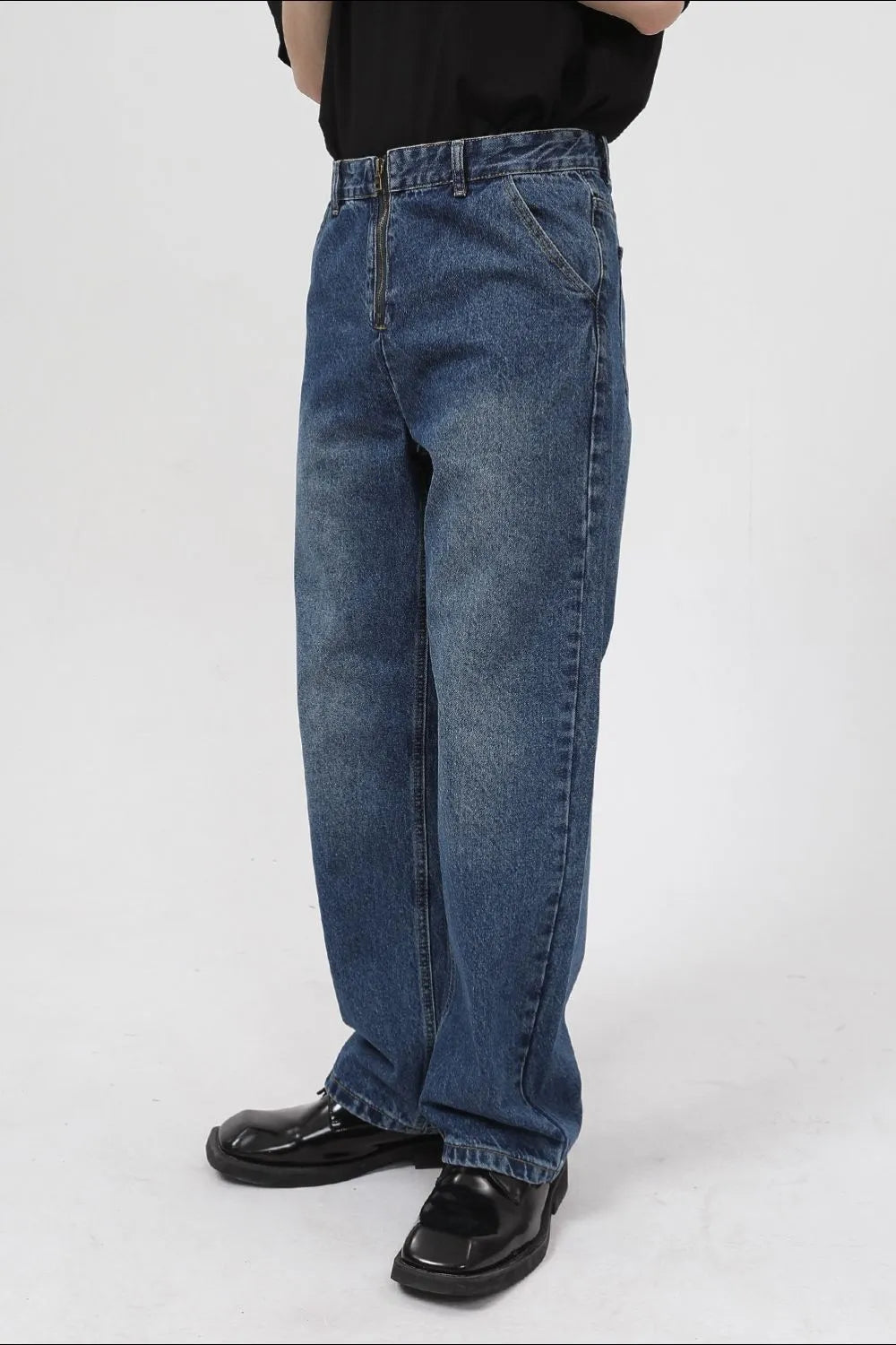 Zip-front relaxed fit denim jeans in medium wash, with a baggy cut.