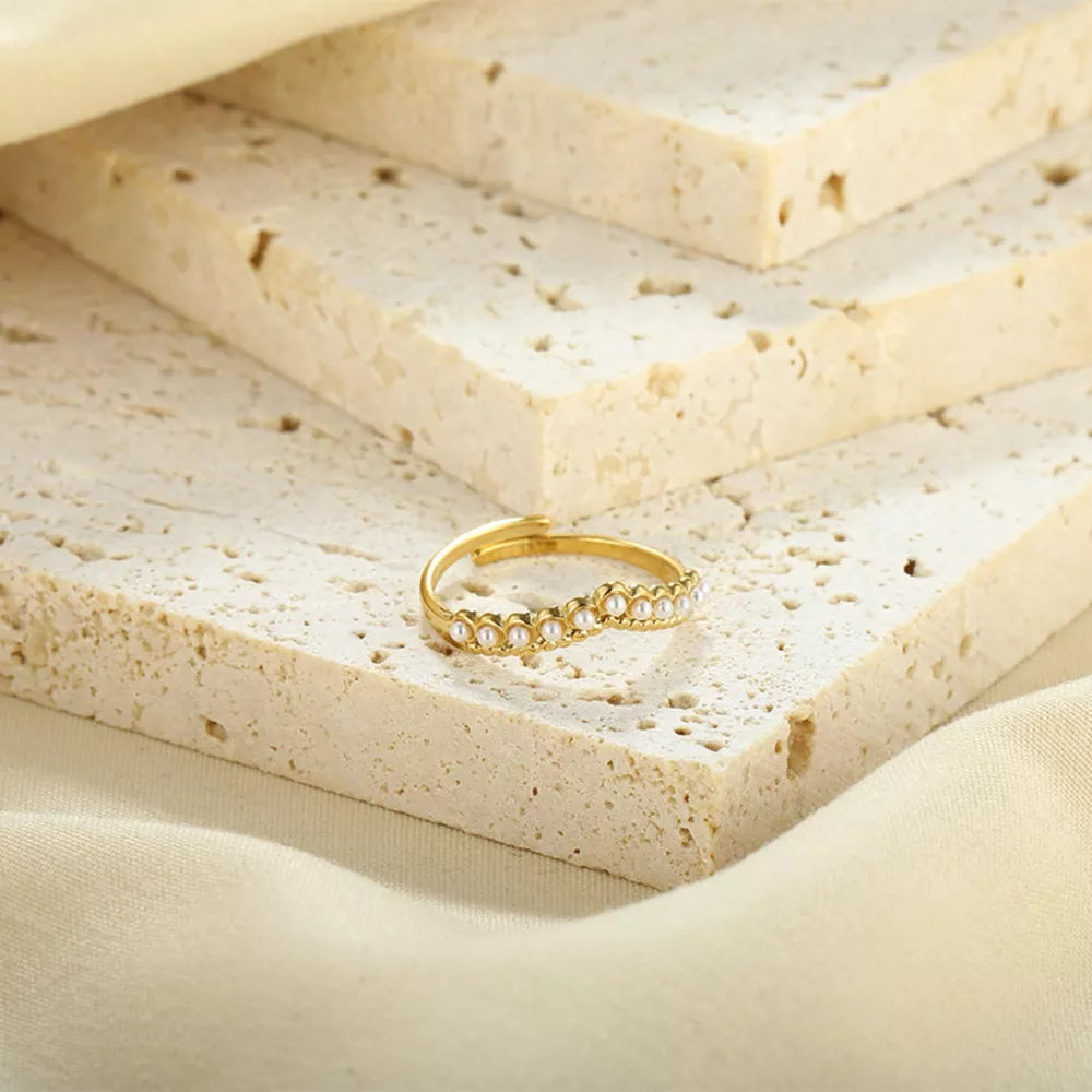 Gold adjustable ring with delicate pearl embellishments along the band.