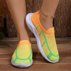 Geometric knit slip-on trainers in yellow and orange with green accents and white soles.