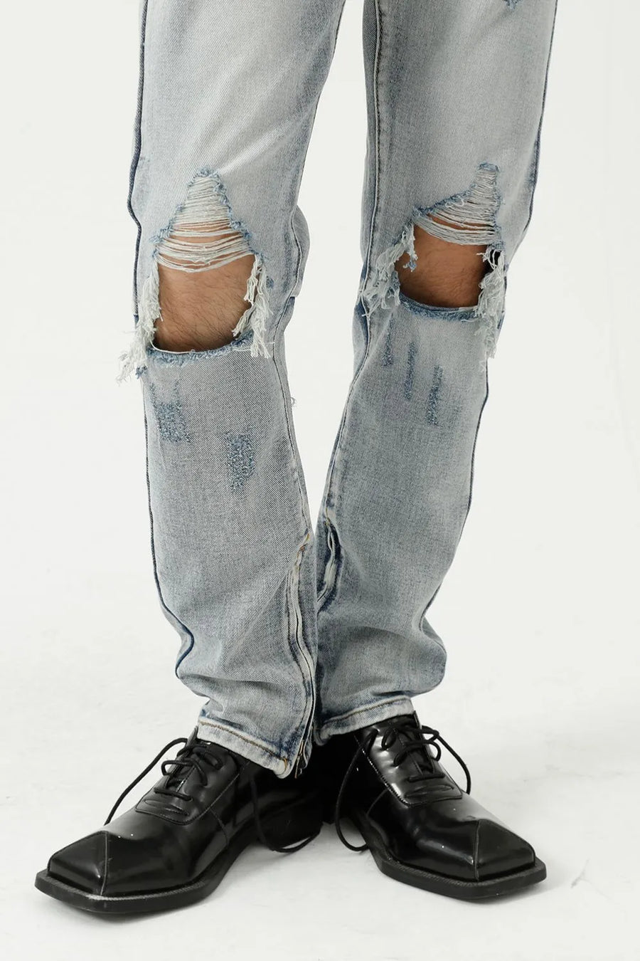 Light wash denim slim fit jeans with ripped knees and distressed details.