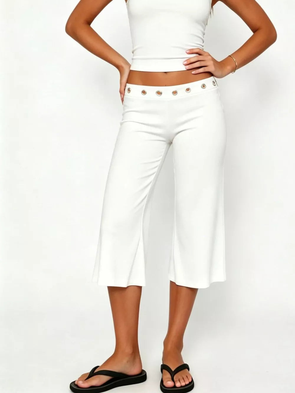 White flared hem capri pants with button detail at the waist