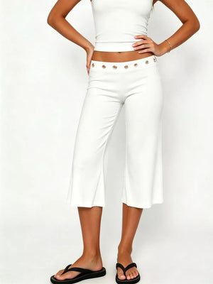 White flared hem capri pants with button detail at the waist