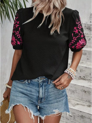 Black embroidered puff sleeve blouse with pink floral detail on sleeves.