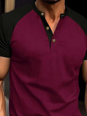 Burgundy and black raglan henley polo shirt with textured fabric and gold buttons.