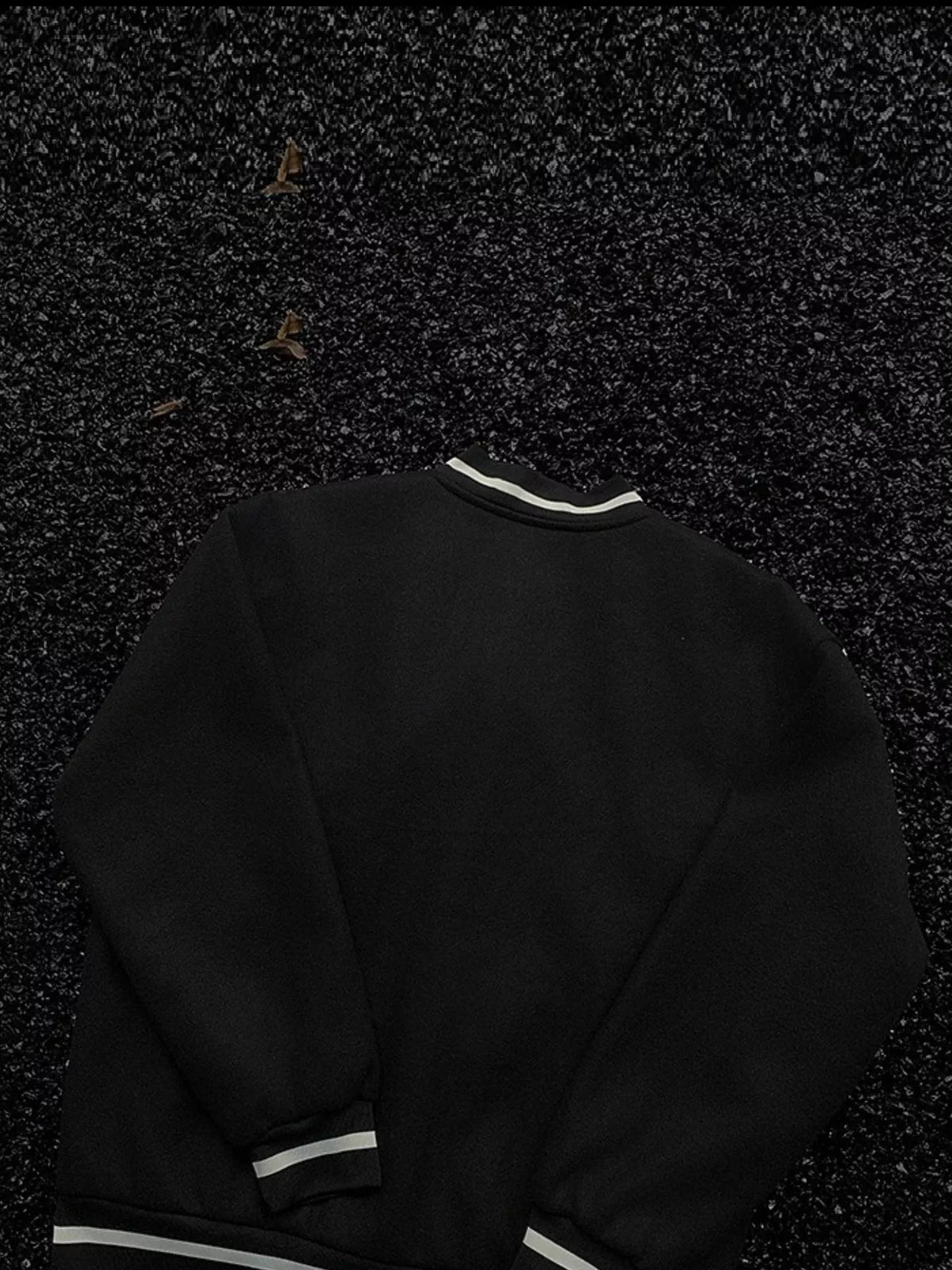 Black bomber jacket with white striped collar, cuffs, and hem