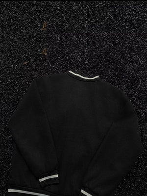 Black bomber jacket with white striped collar, cuffs, and hem