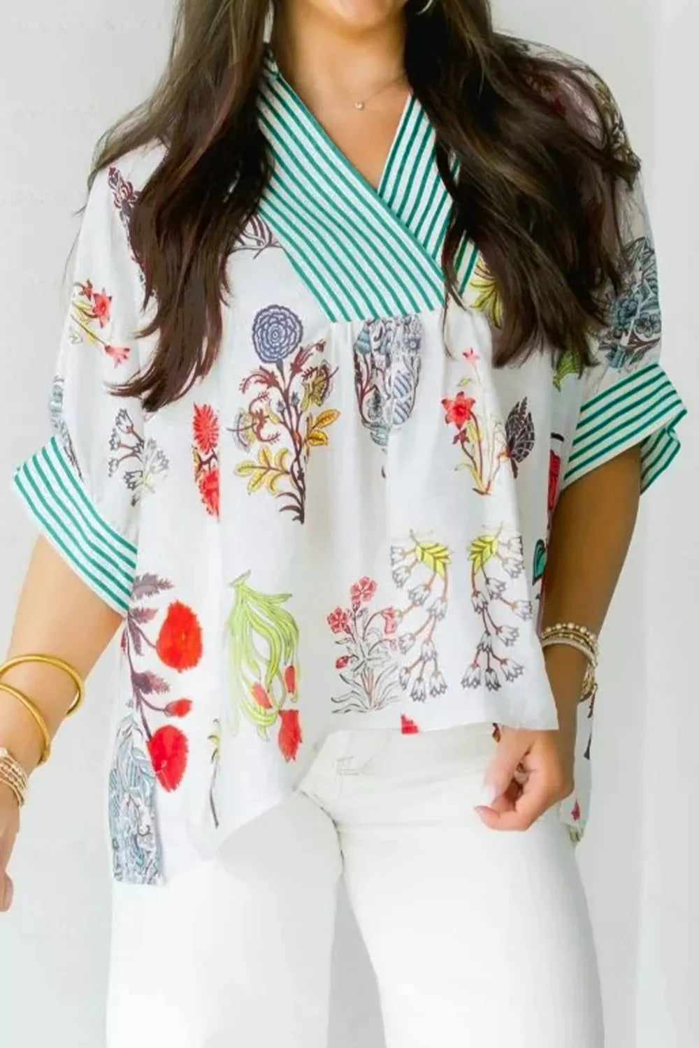 Vibrant floral print shirt with green striped contrast trim and V-neck.