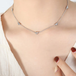 Silver chain necklace with small heart-shaped zirconia charms.