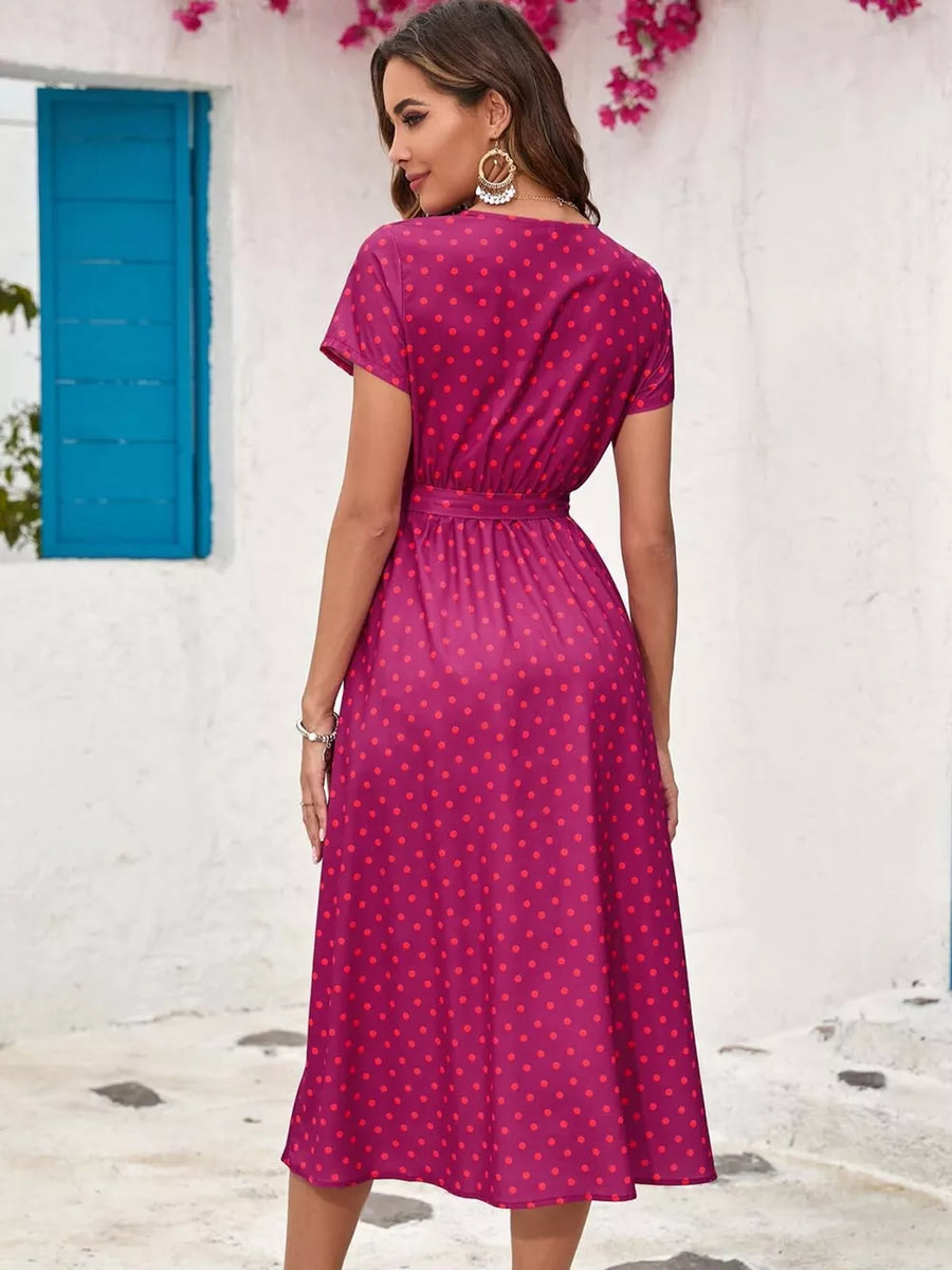 Pink polka dot midi dress with short sleeves and a tie waist.