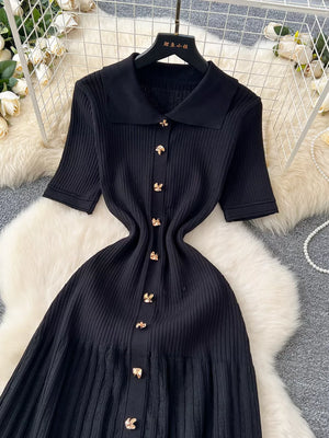 Black knit Peter Pan collar dress with gold button details and short sleeves.