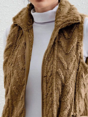 Camel faux fur zip-up vest with a stand-up collar, layered over a white turtleneck.