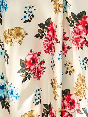 Chic floral midi dress with red, blue, and gold roses on a cream background.