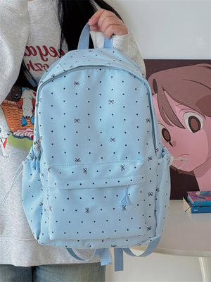 Light blue polka dot backpack with bowknot pattern and front zipper pocket.