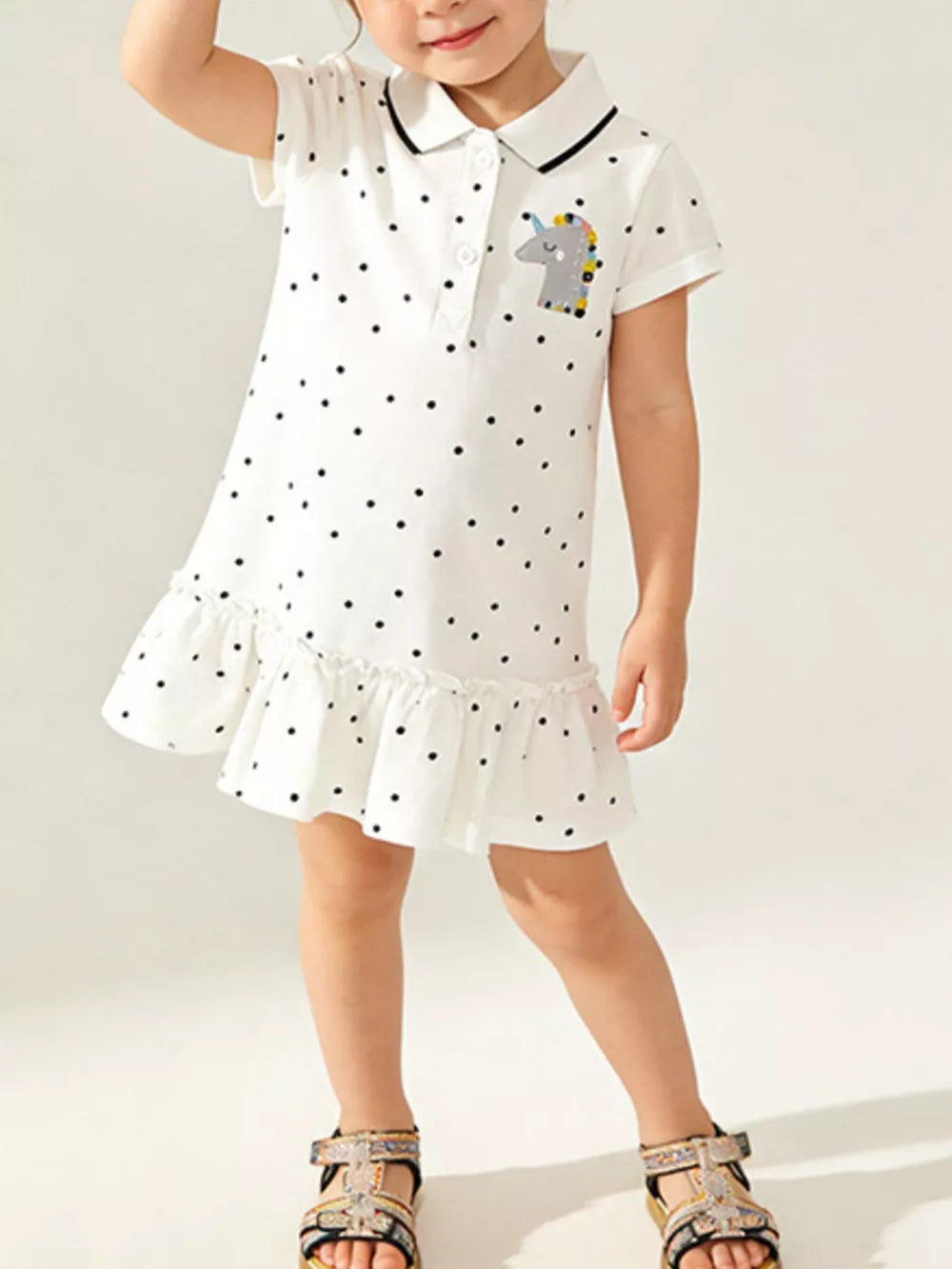 White polka dot cotton polo dress with unicorn patch and ruffled hem for kids