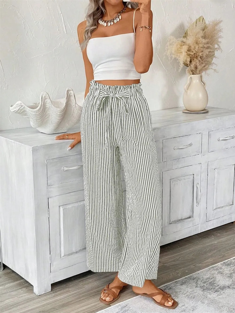 Striped paper bag maternity pants with tie waist and wide leg in black and white.