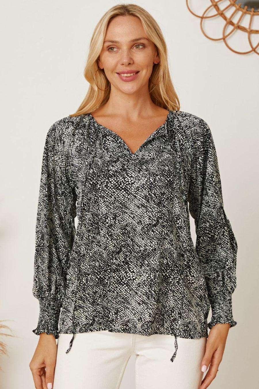 Black serpentine print blouse with gathered sleeves and V-neckline.