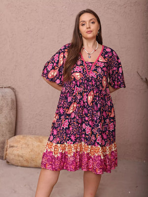Plus-size floral flutter dress with ruched bodice and tiered border hem.