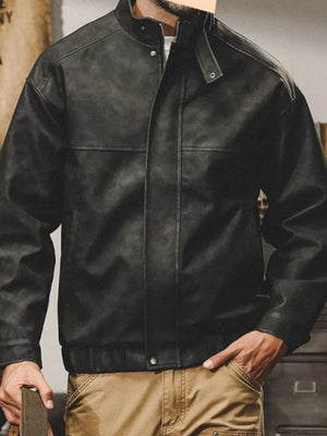 Black distressed leather bomber jacket with stand collar and snap details.