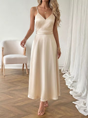 Cream V-neck maxi dress with spaghetti straps, ruched waist detail, and a-line skirt.