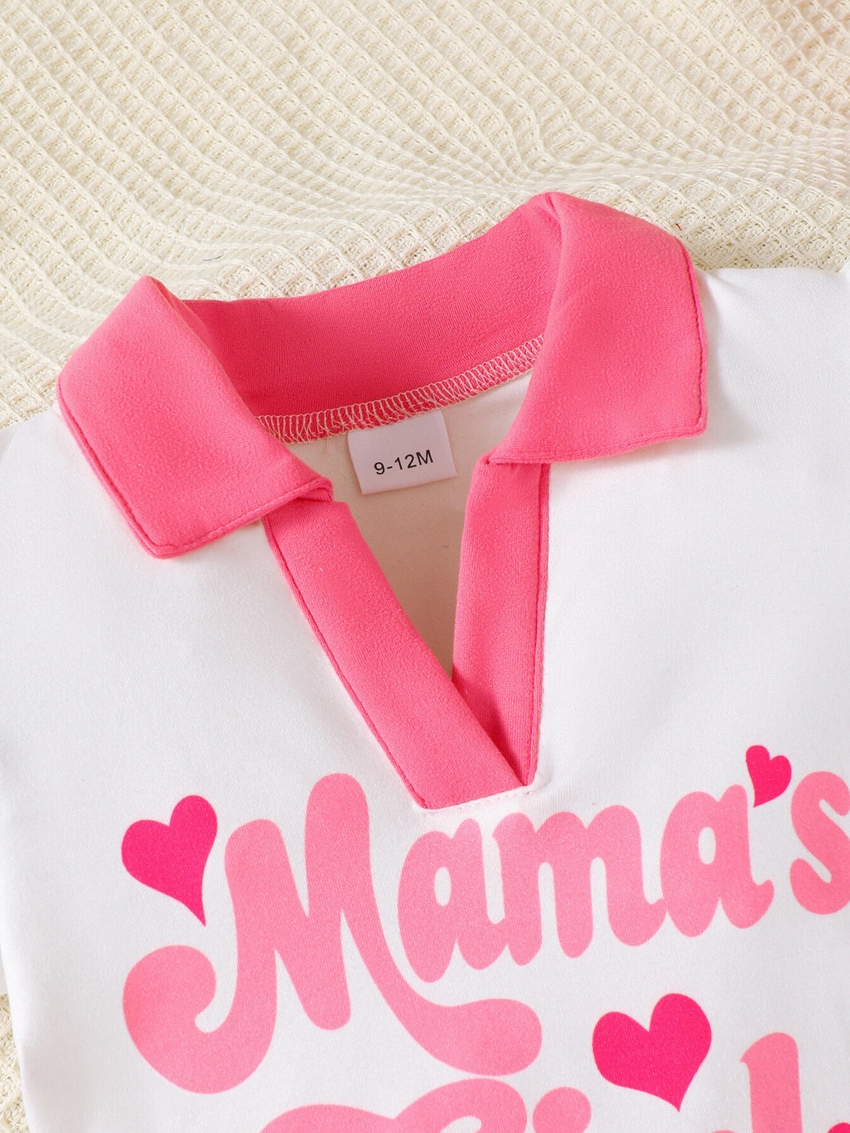 White short sleeve top with pink collar and "Mama's Girl" graphic with hearts.