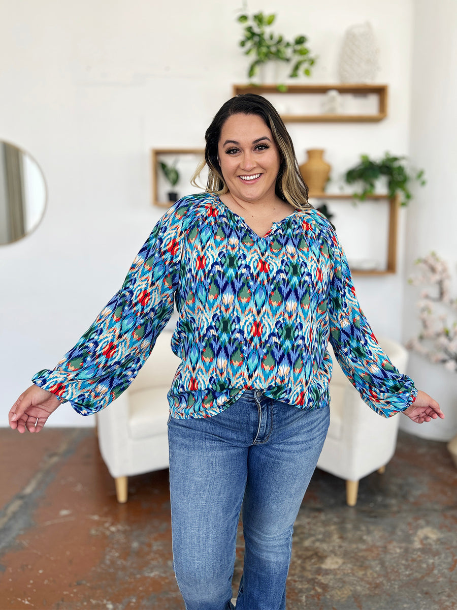 Prismatic ikat blouse in blue with voluminous sleeves and a v-neck.