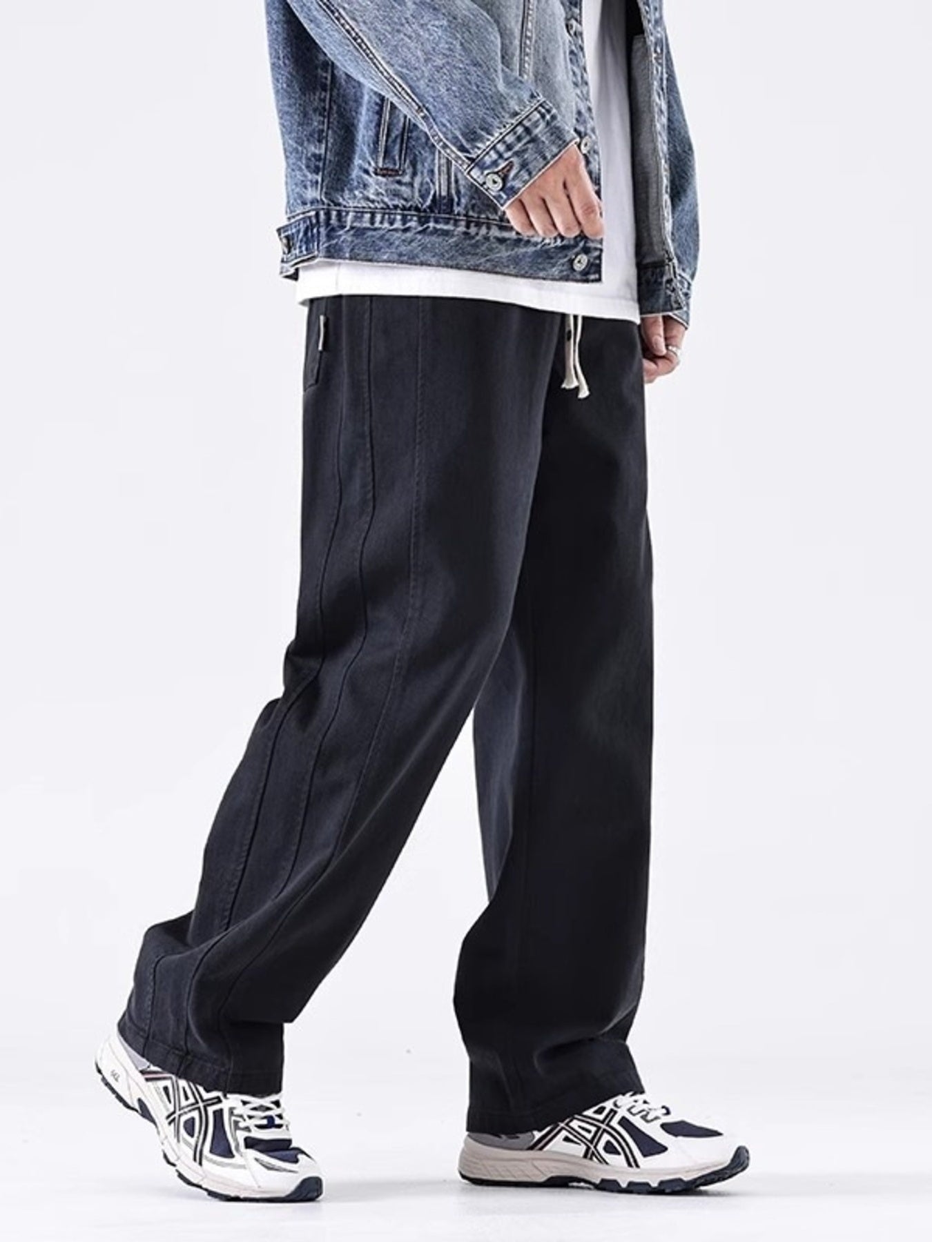 Men's black loose fit drawstring sweatpants with contrast stitching detail.