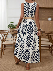 Belted midi dress with a tropical leaf print, natural fiber belt, and sleeveless design.