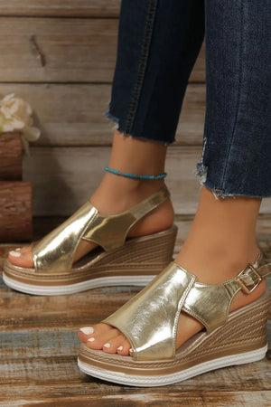 Gold metallic wedge sandals with crisscross detail and buckle ankle strap.