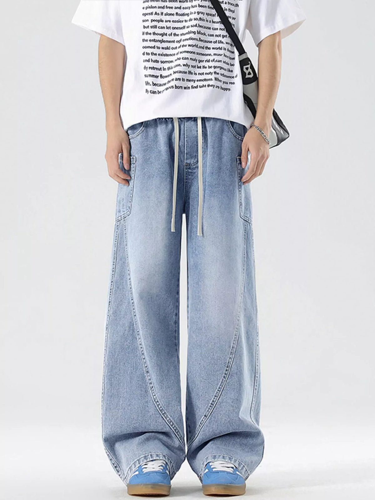 Light blue wide-leg jeans with drawstring and panel detailing.